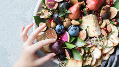 Hand picking up fruit out of a bowl